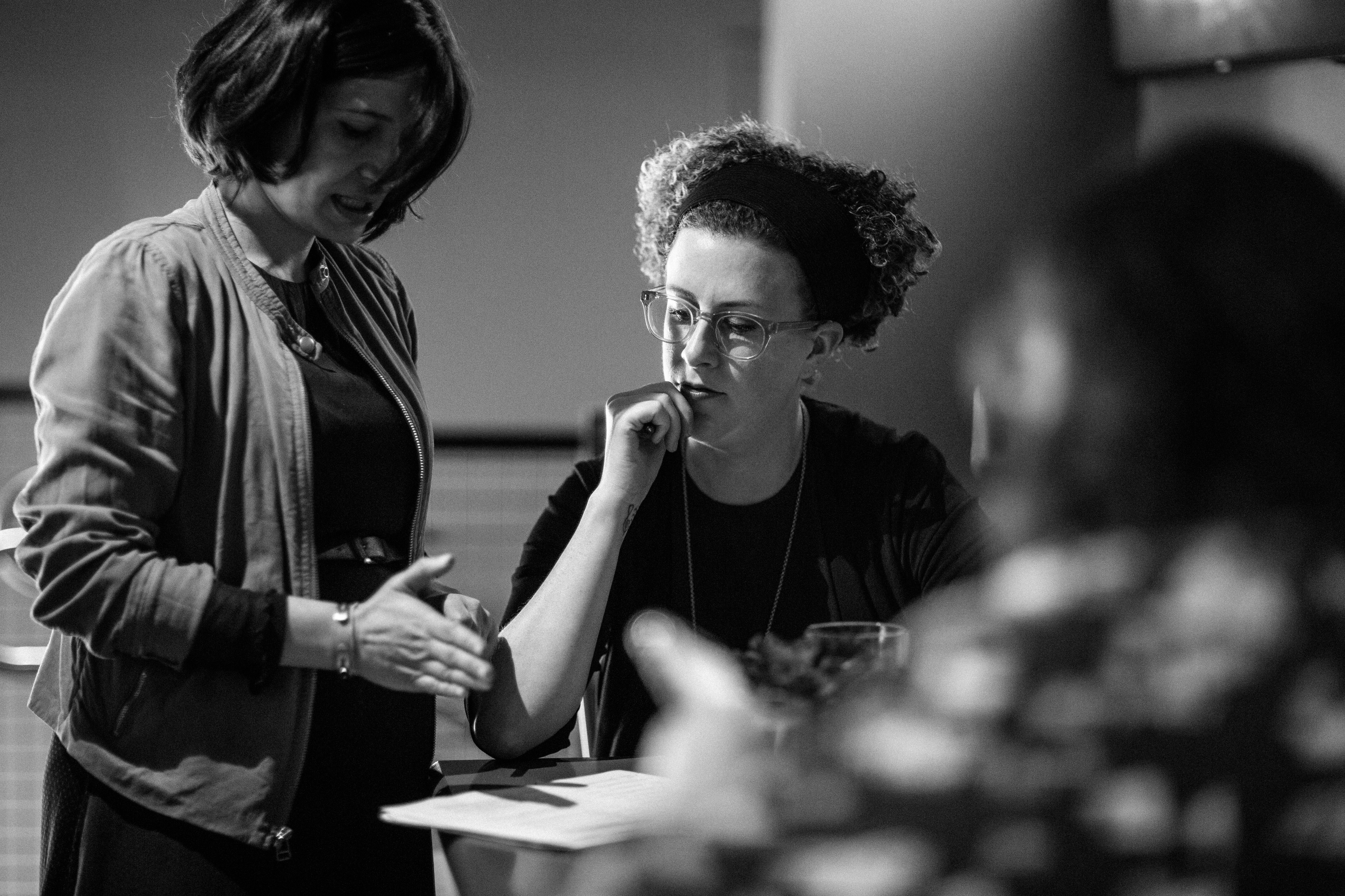 Two women in conversation during a Drawn design workshop, black and white