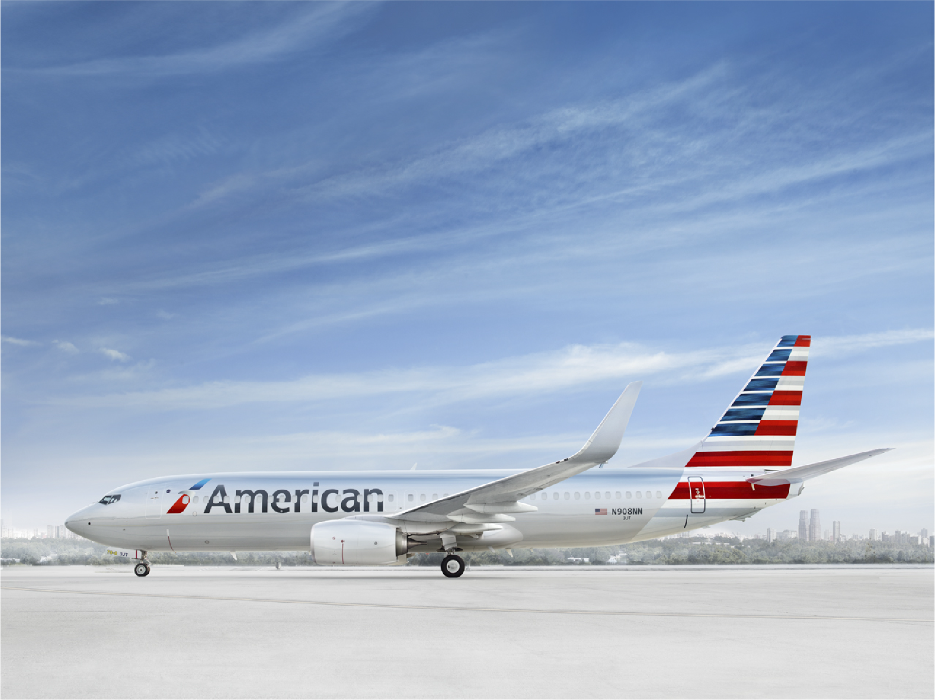 American Airlines jet parked on the tarmac under a blue sky