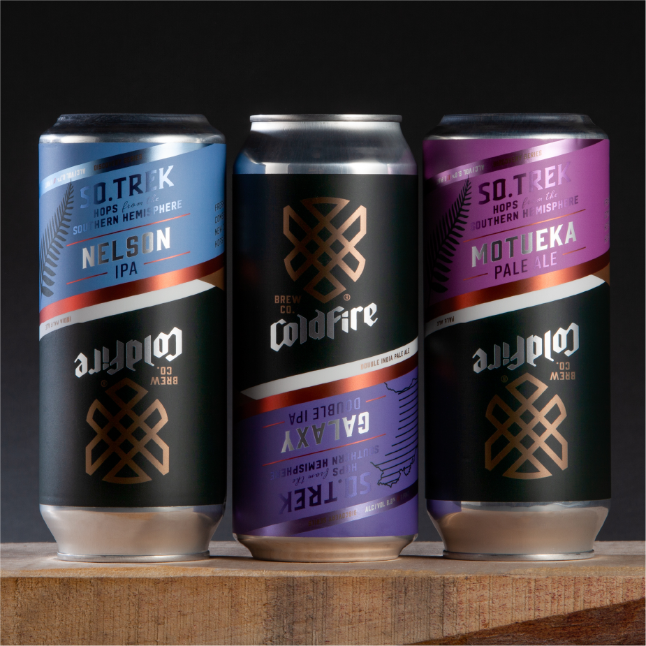 Three ColdFire So.Trek cans: Nelson IPA, Galaxy double IPA, and Motueka pale ale on a wood surface