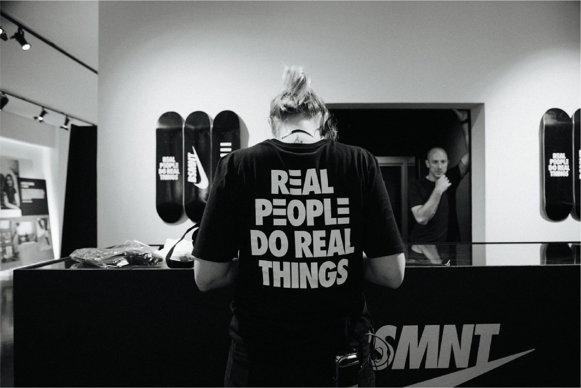 Nike London BSMNT store interior with a person in a 'Real People Do Real Things' tee at the counter