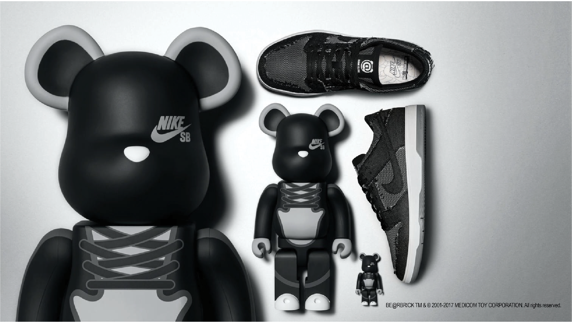 Nike SB x Bearbrick black figures displayed beside matching Nike Dunk sneakers