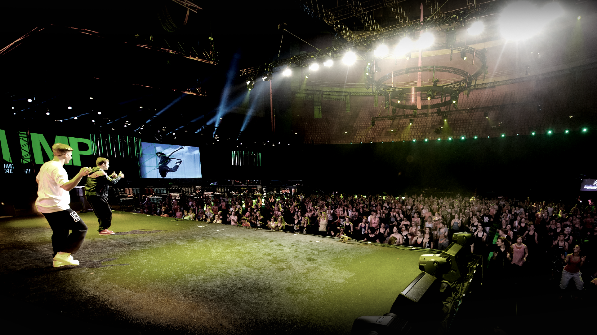 Nike London performers on stage before a large crowd at an arena under green stage lights