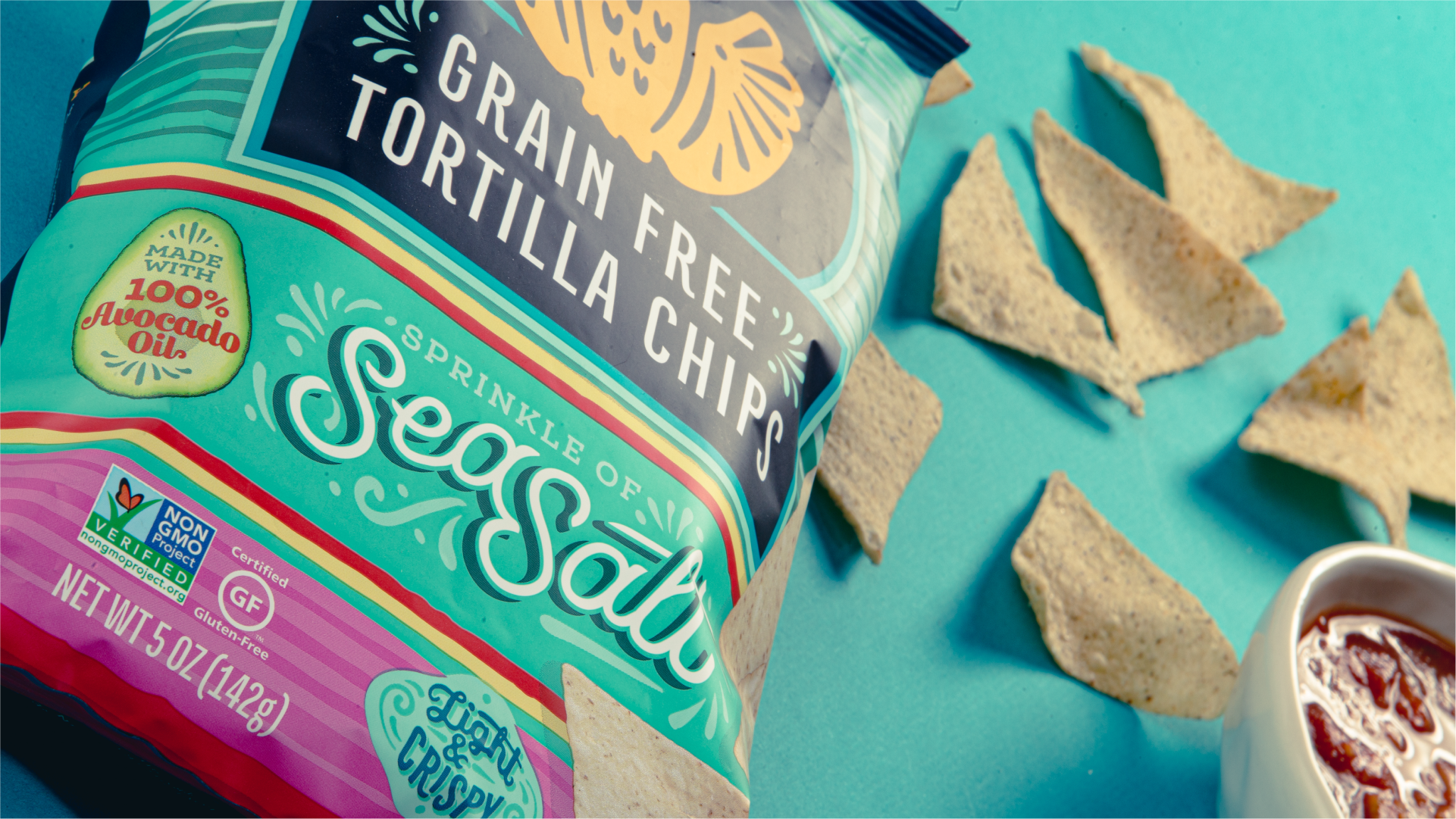 Siete Grain Free Tortilla Chips Sea Salt bag with tortilla chips and salsa on blue