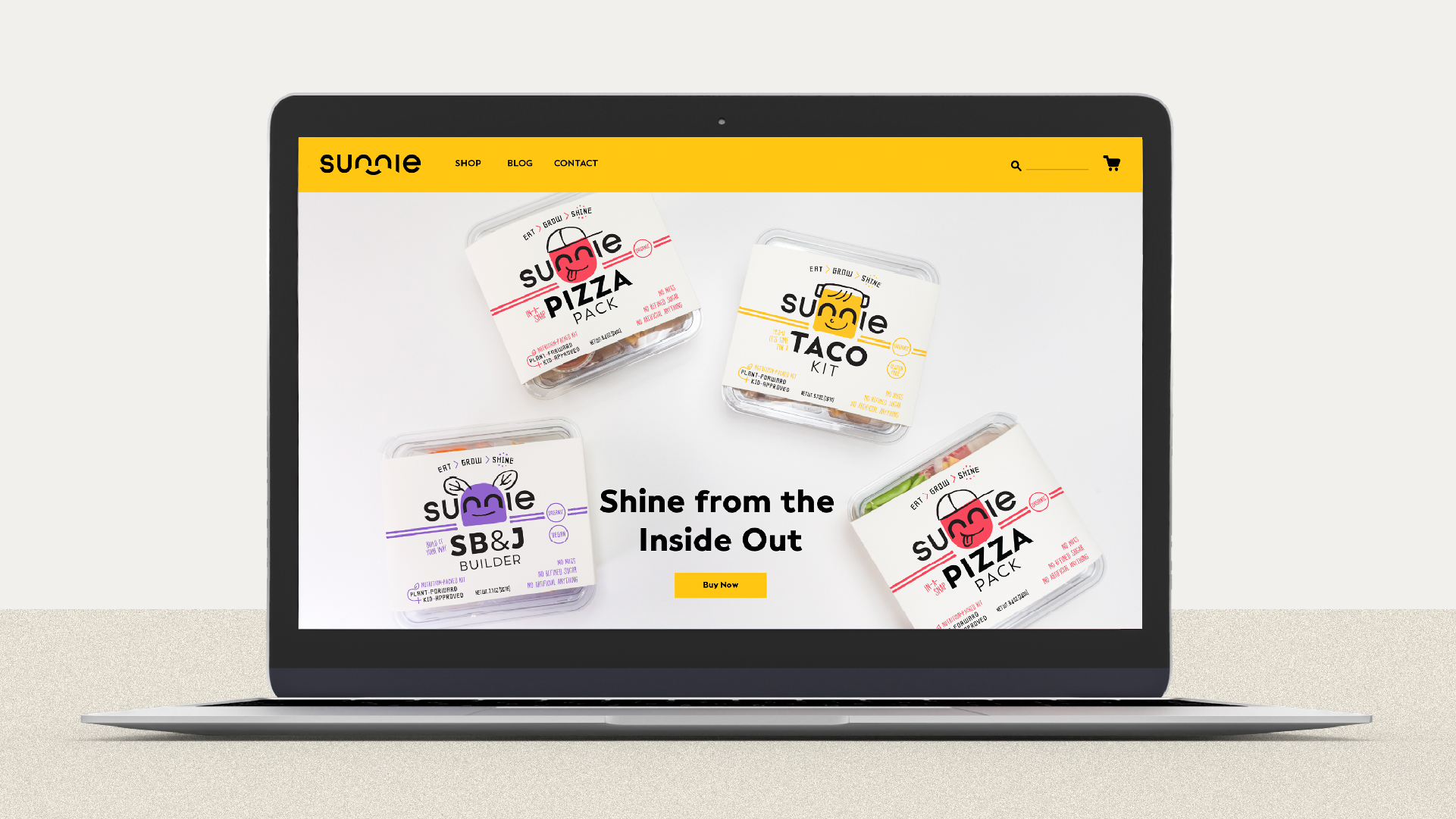 Laptop showing the Sunnie e-commerce site with lunch kits and 'Shine from the Inside Out' headline