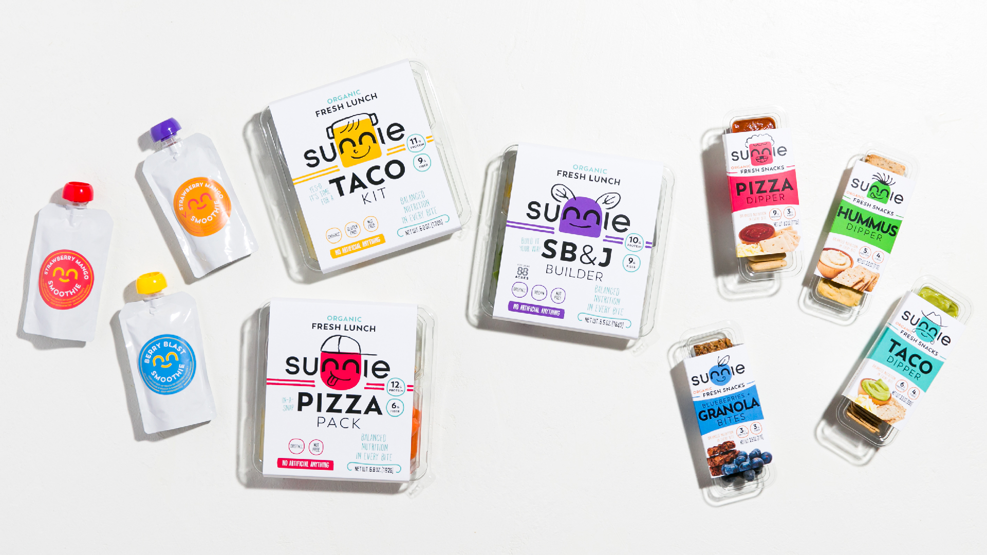 Flatlay of the Sunnie product line: Taco Kit, SB&J Builder, Pizza Pack lunch boxes, pouches and snack packs