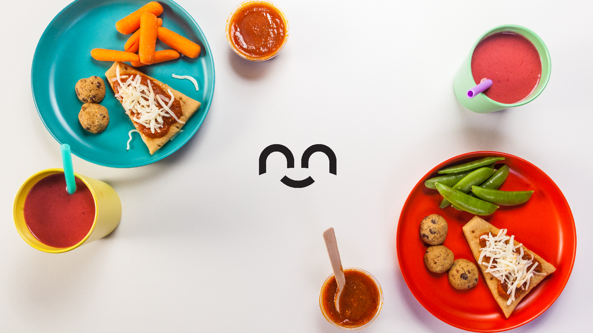 Sunnie kids' lunch components on bright plates with smoothie cups and the brand smile mark