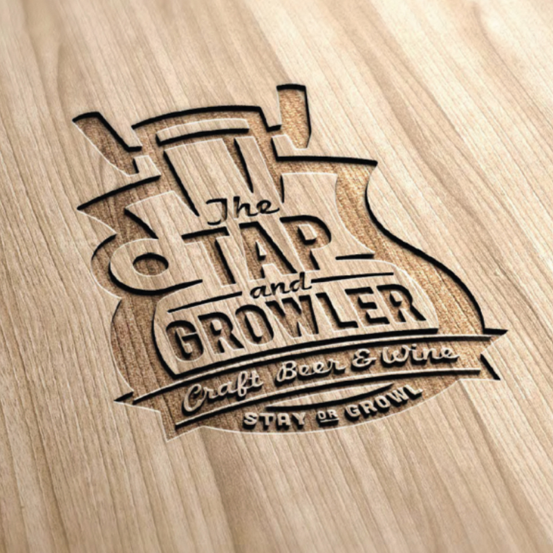 The Tap and Growler 'Craft Beer & Wine' logo engraved into a wood surface