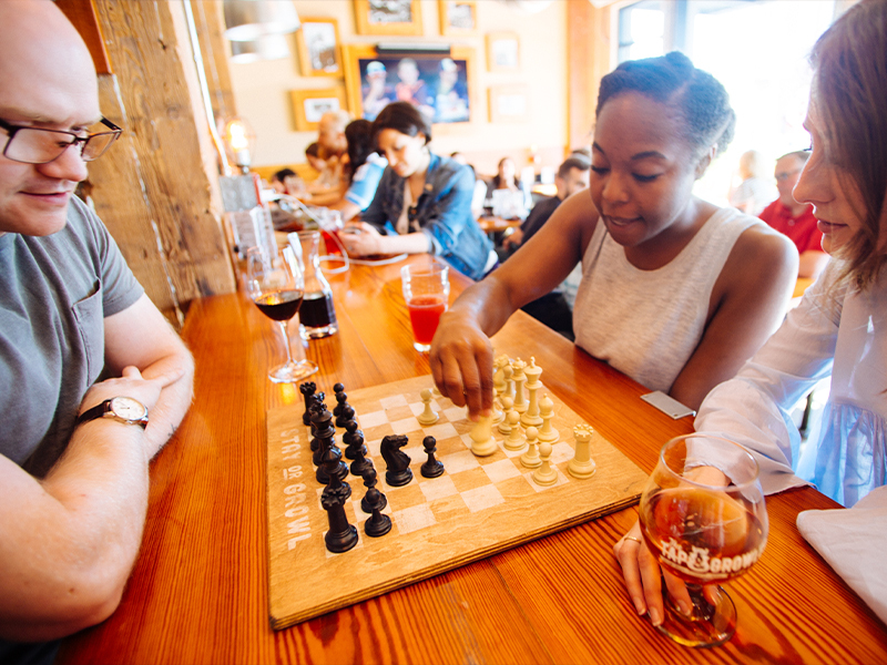 Overhead spread of food and drinks at the Tap and Growler: nachos, charcuterie, salads and beer