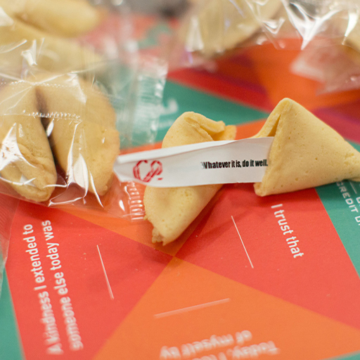 WSECU Let's Co fortune cookies on a branded card, slip reads Whatever it is, do it well