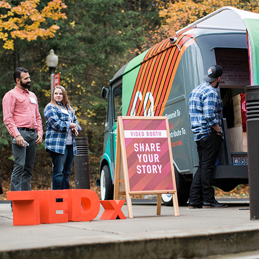 People by the WSECU Let's Co van and a Share Your Story video booth at a TEDx event