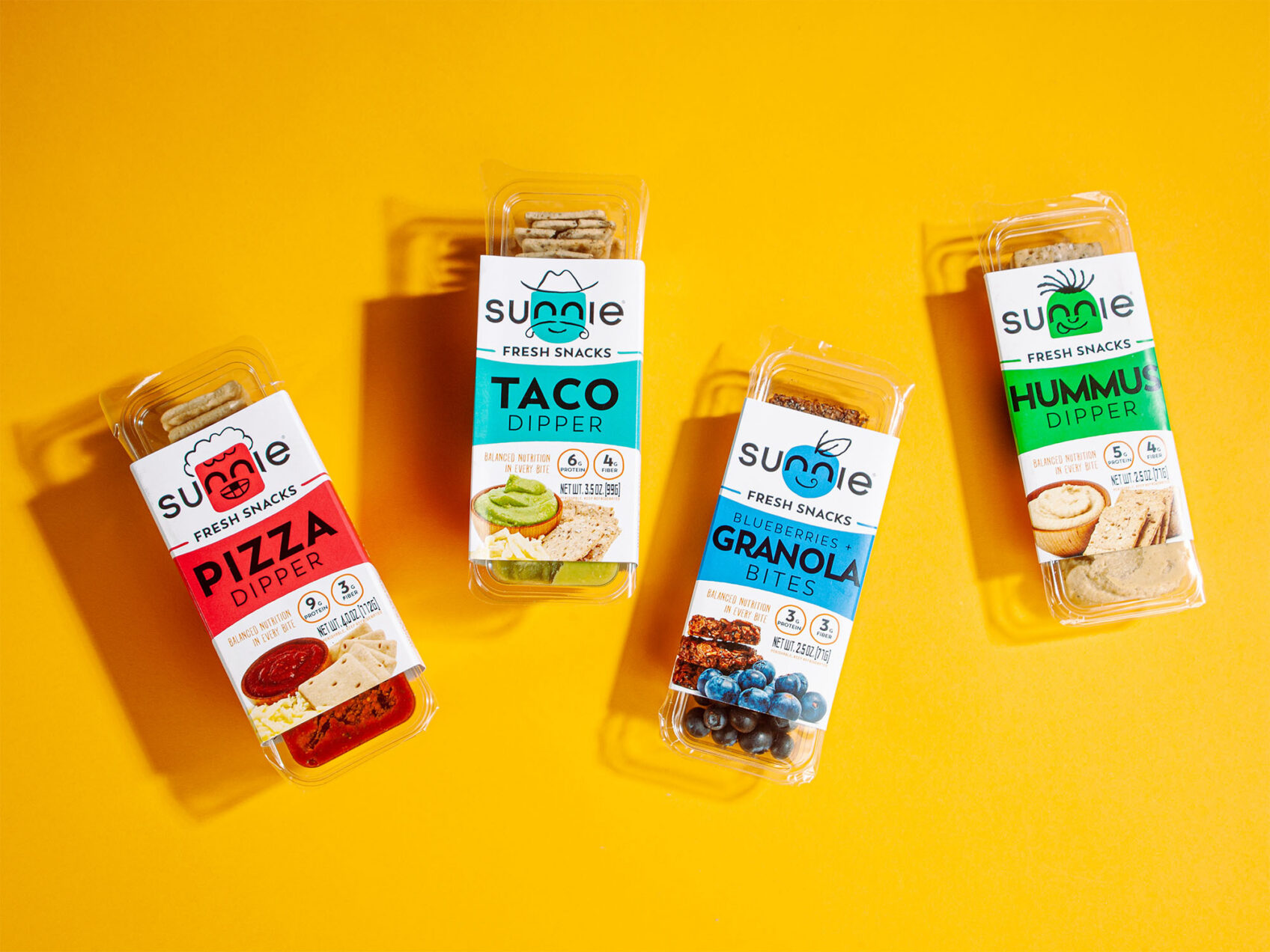 Sunnie Fresh Snacks lineup: Pizza, Taco, Granola Bites and Hummus dippers on a yellow background
