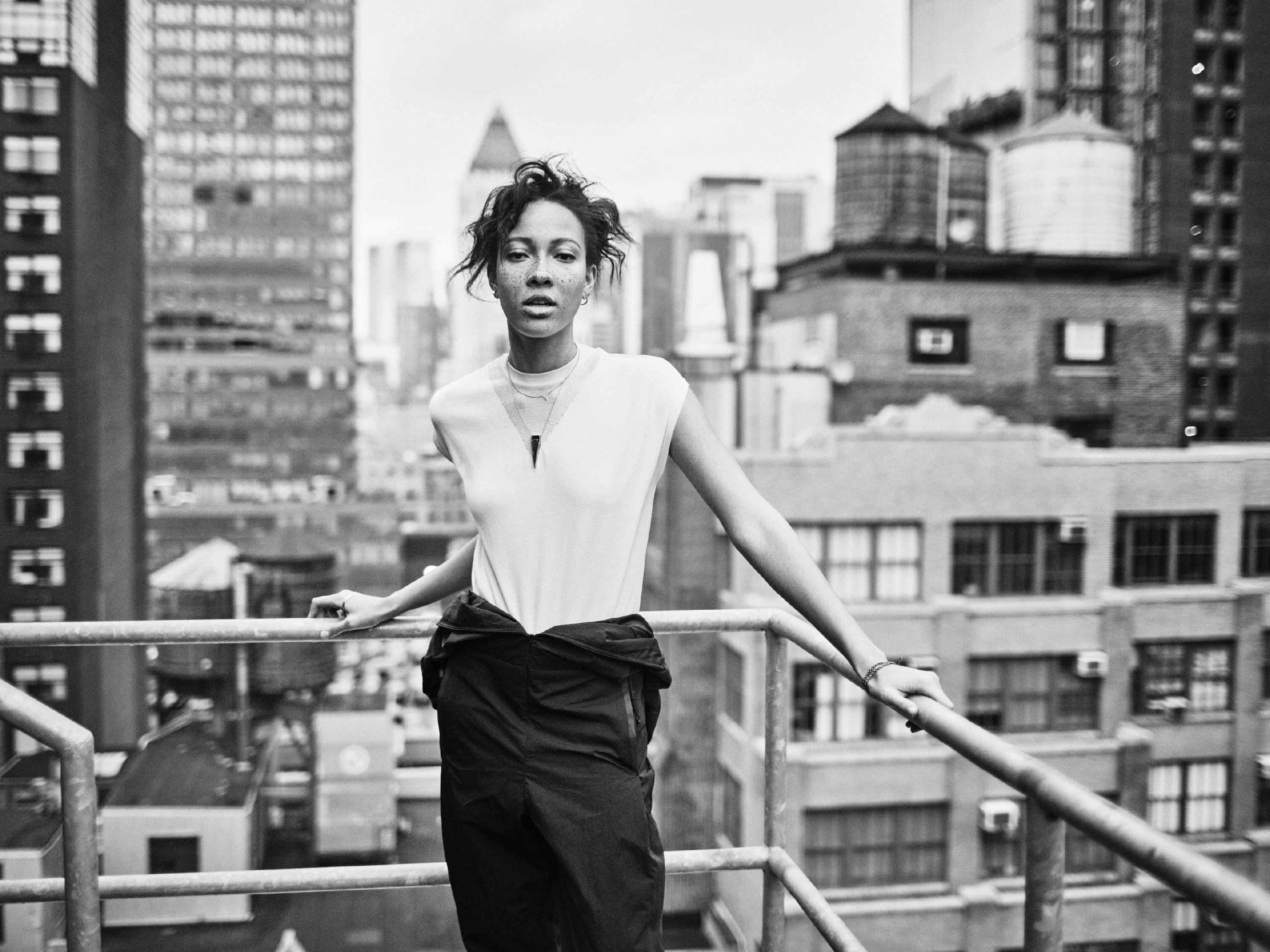 Nike London: woman in white top on a rooftop railing against a city skyline, black and white
