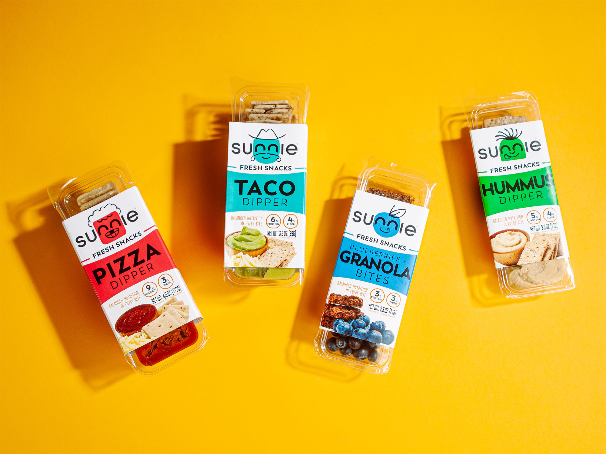 Sunnie Fresh Snacks lineup: Pizza, Taco, Granola Bites and Hummus dippers on a yellow background