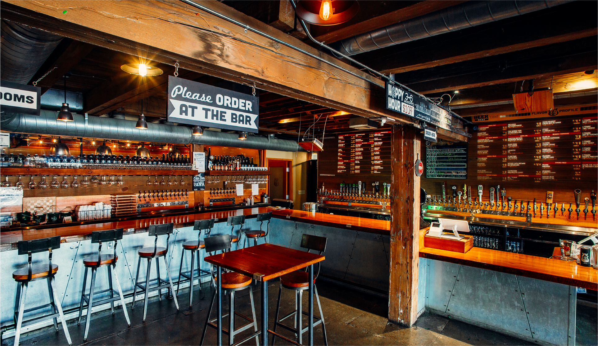 The Tap and Growler taproom interior with bar seating and a "Please Order at the Bar" sign