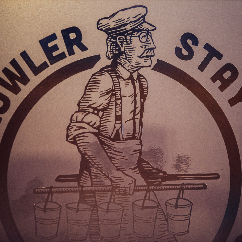 Vintage etched logo of a man carrying buckets on a yoke, text "GROWLER STA" around
