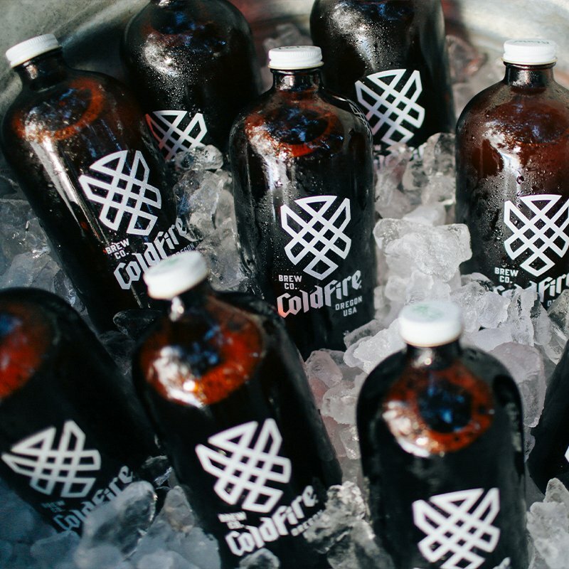 ColdFire Brewing growler bottles with white knotwork logo chilling on ice