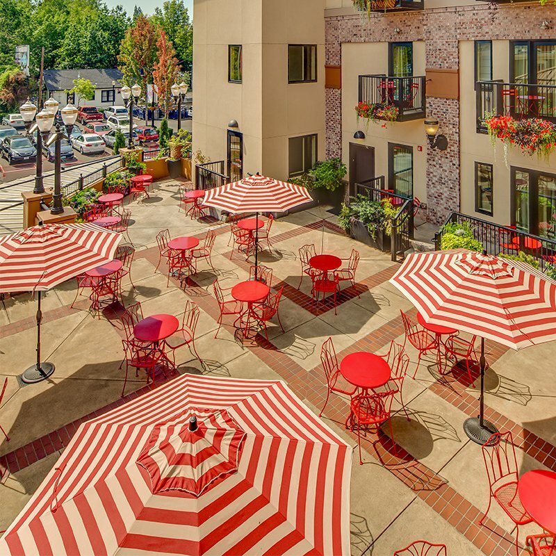 Overhead view of a courtyard patio with red-and-white striped umbrellas at 5th Street Market
