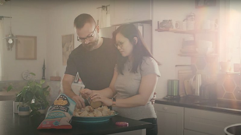 Couple cooking together in a kitchen with a Siete tortilla chip bag on the counter