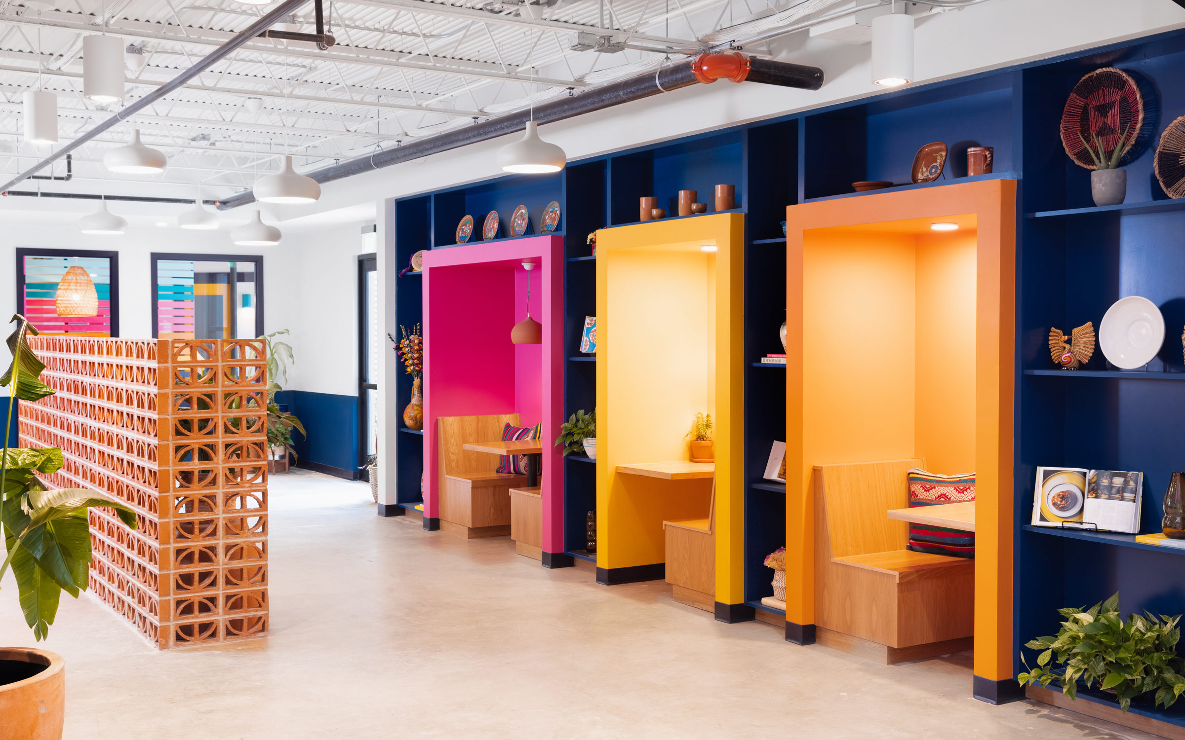 Siete office corridor with magenta, yellow and orange display nooks against a navy shelf wall