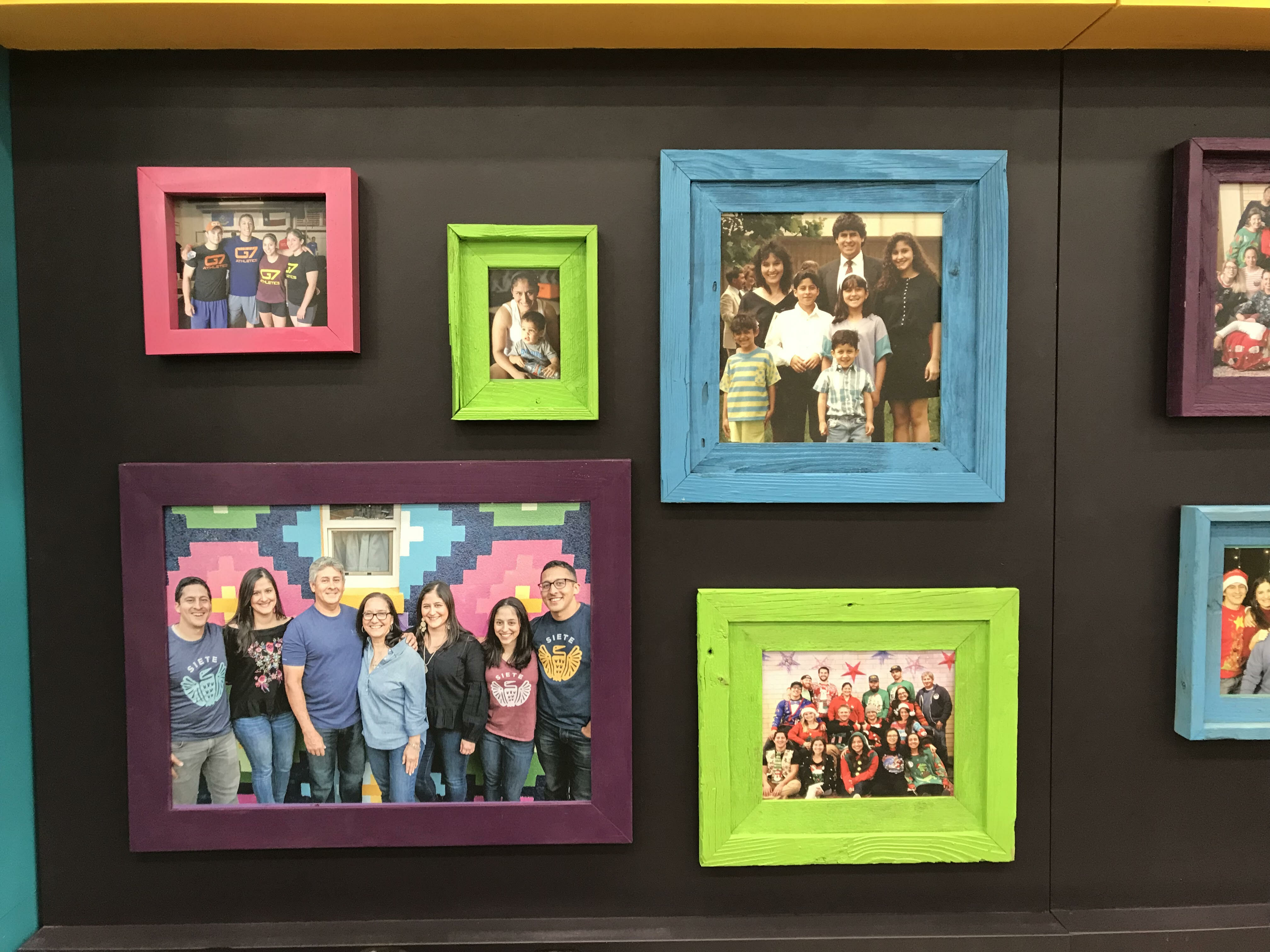 Wall of family photos in bright colored frames on Siete's trade show booth