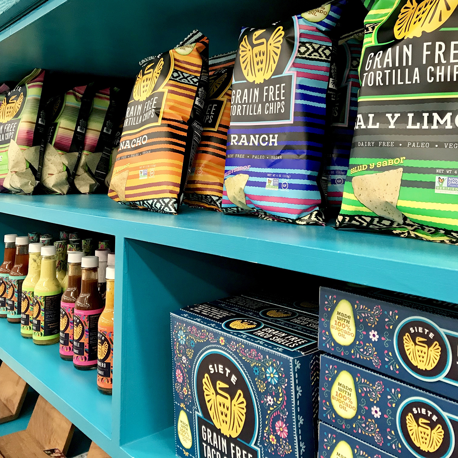 Retail shelf of Siete grain-free tortilla chip bags, hot sauce bottles and taco shell boxes