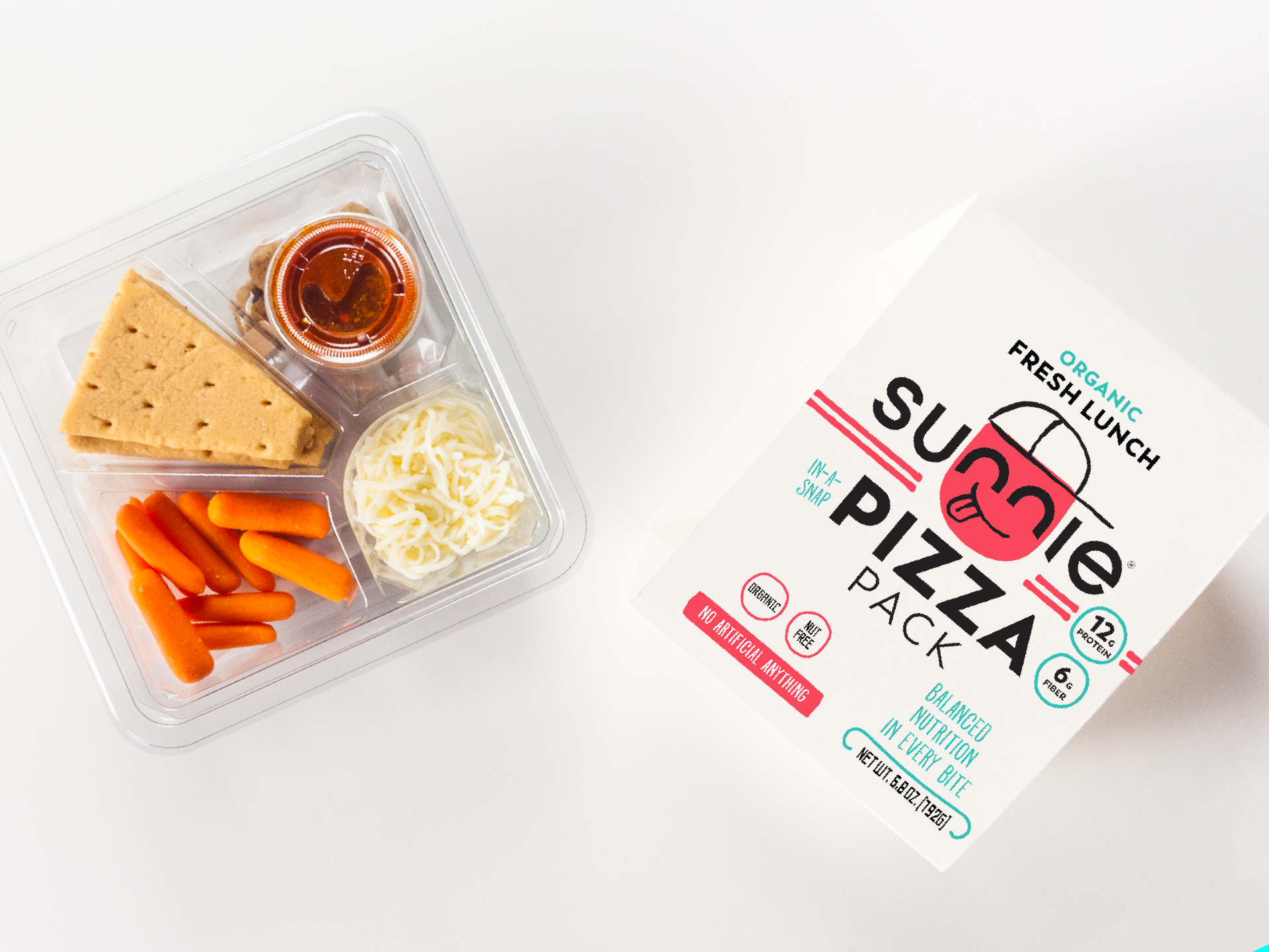 Open Sunnie Pizza Pack tray with crackers, carrots and cheese beside its box on white
