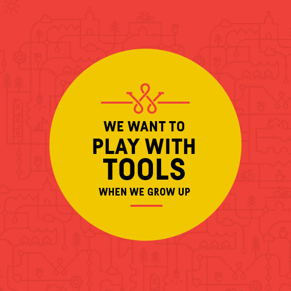 Yellow circle badge reading 'We want to play with tools when we grow up' on Wolcott red pattern