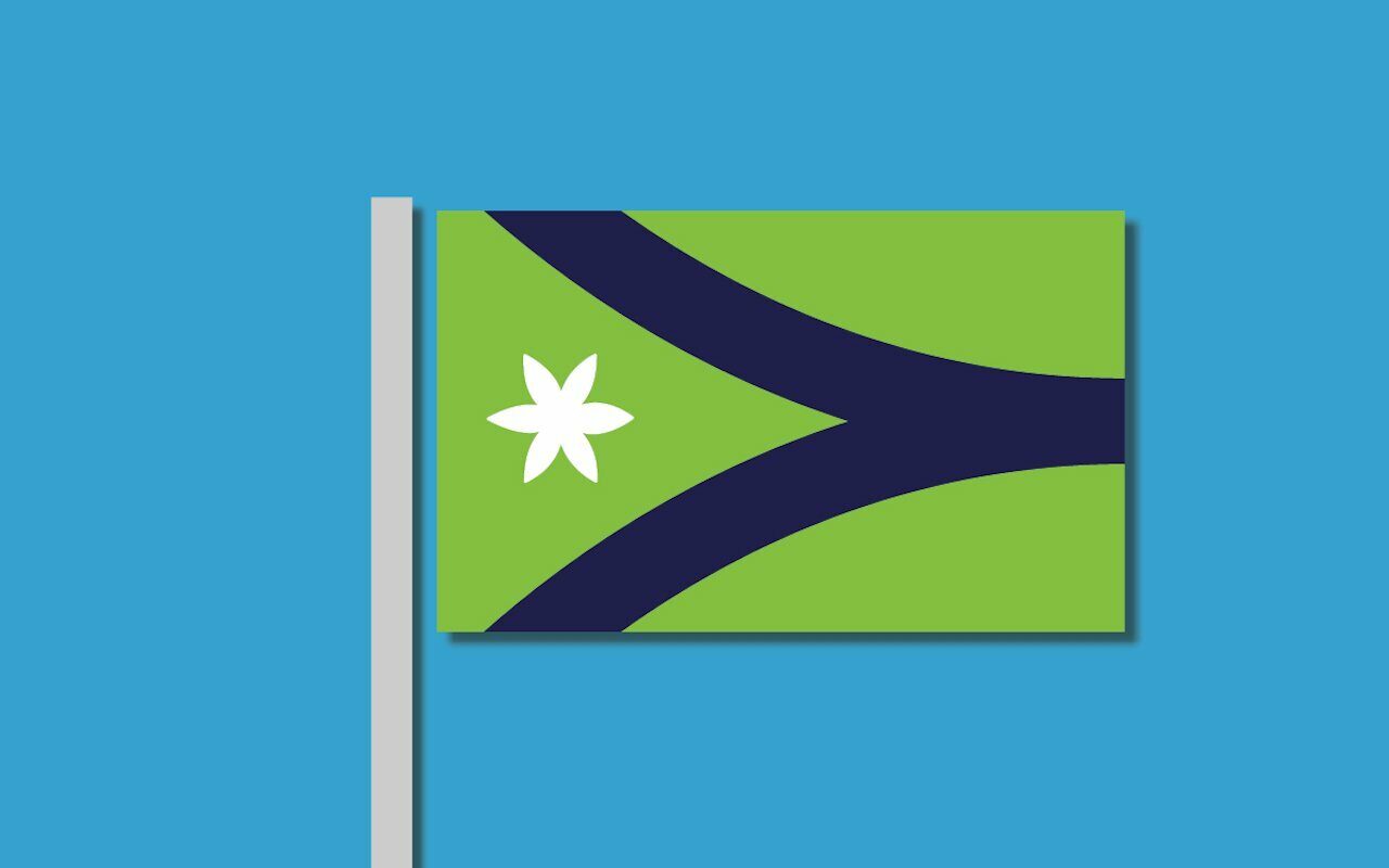 Concept flag design on a pole, navy Y-shape and white six-point flower on a green field against blue sky