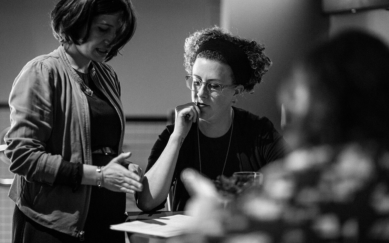 Black-and-white photo of two Drawn team members in discussion at a service design work session