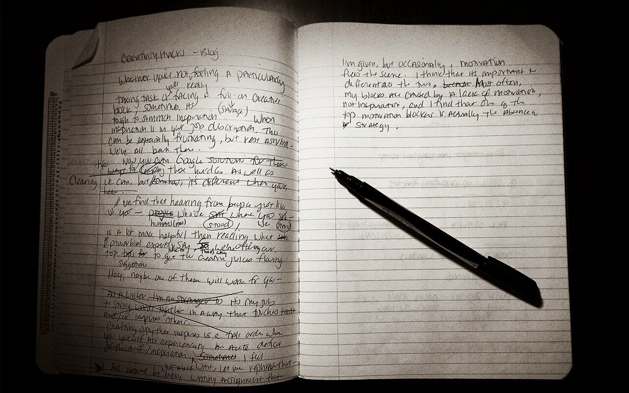 Open notebook with handwritten notes and a pen, low light, for the Why Words Matter essay