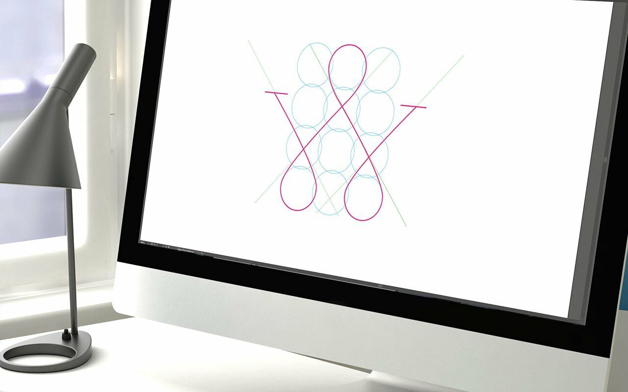 Computer monitor displaying a logo constructed from geometric circles and red curves