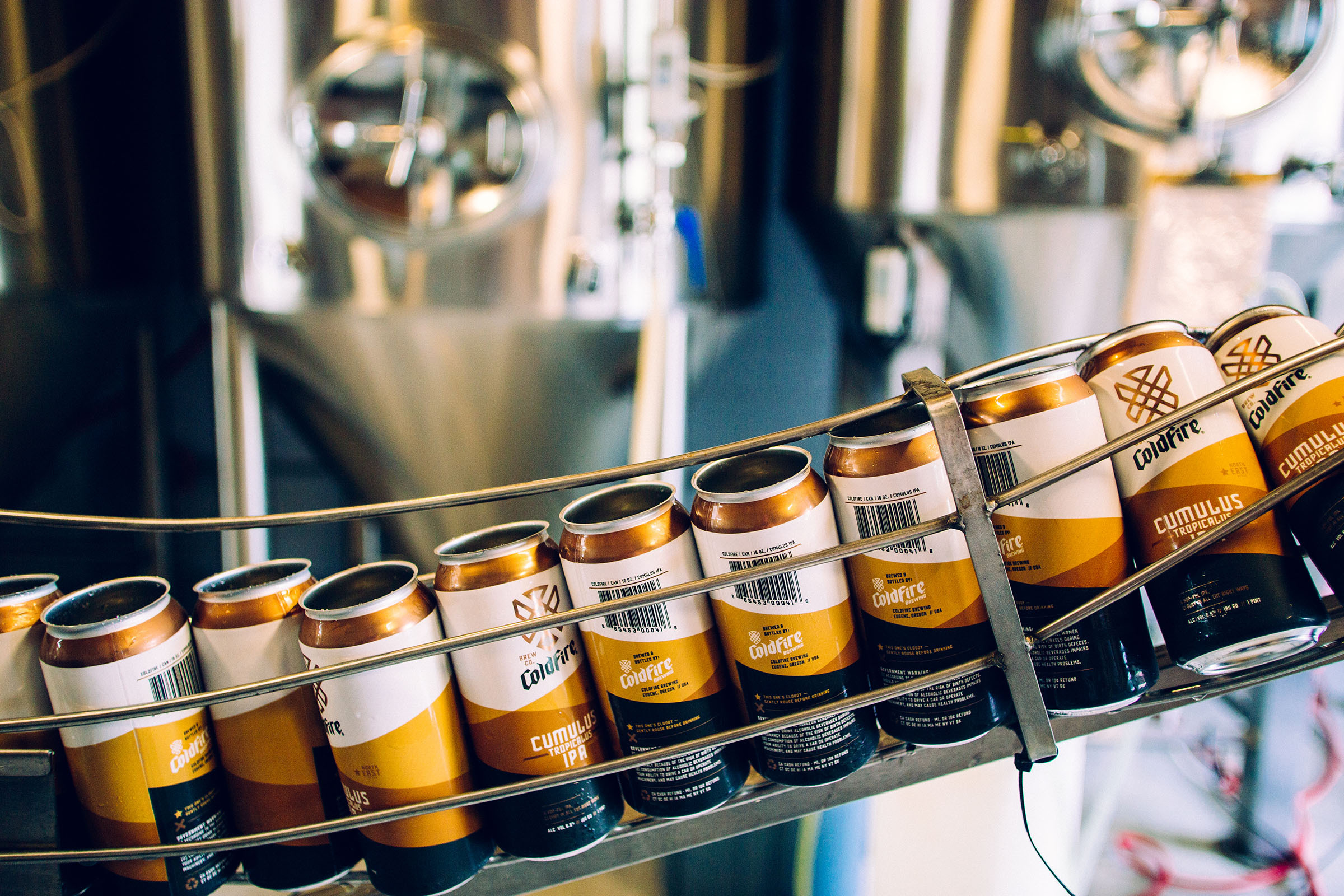 ColdFire Brewing and Cumulus cans moving along a canning line at the brewery