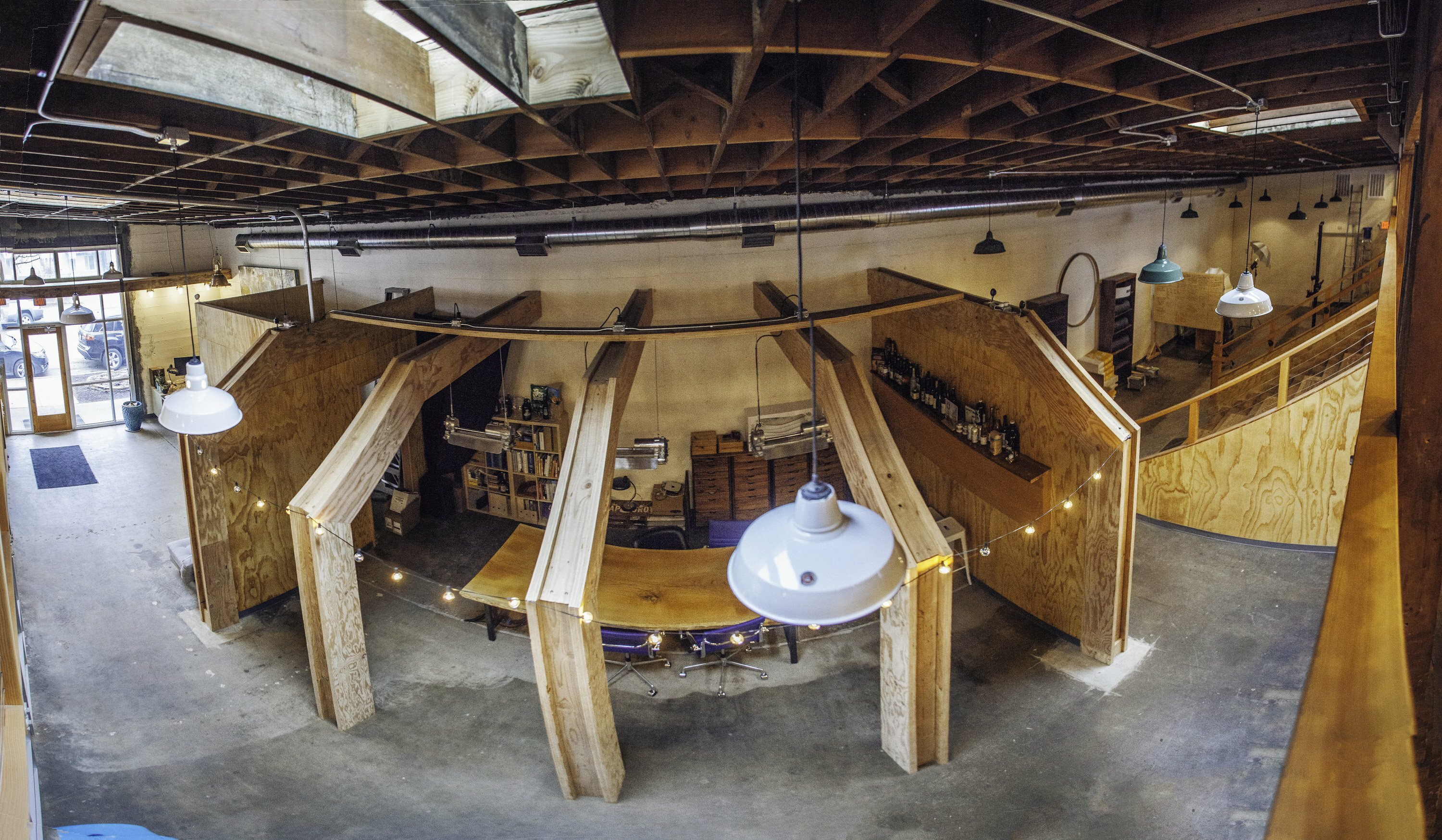 Open-plan interior of Drawn's Bard space with timber beams, exposed ceiling and central bar