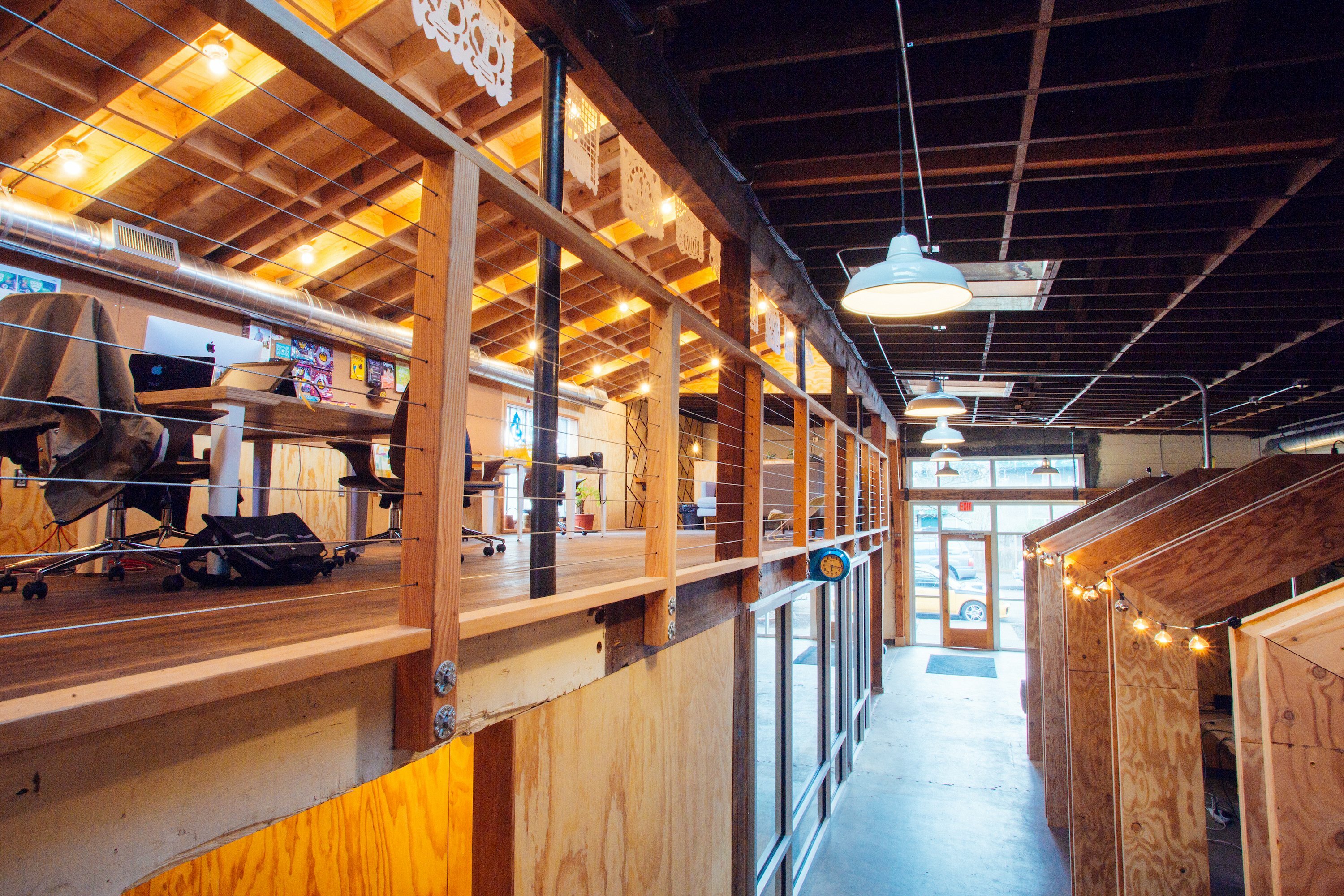 Interior walkway in Drawn's Bard with raised desks, cable railing and pendant lights