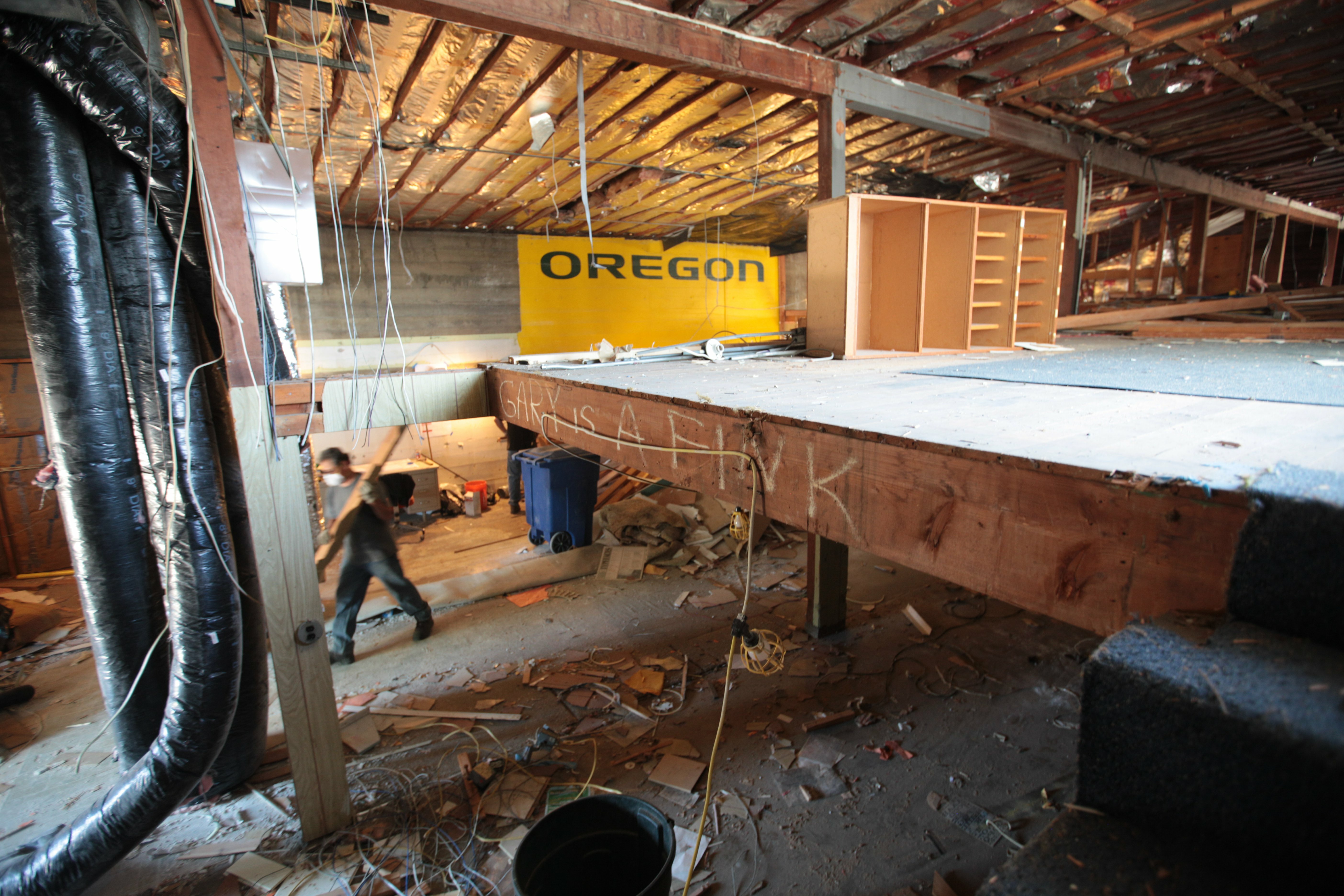 Gutted upper floor mid-renovation with exposed joists and a yellow Oregon sign during the Bard salvage
