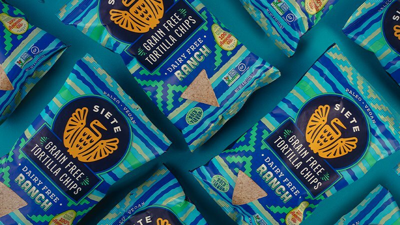 Siete Grain Free Tortilla Chips Dairy Free Ranch bags arranged in a pattern on teal