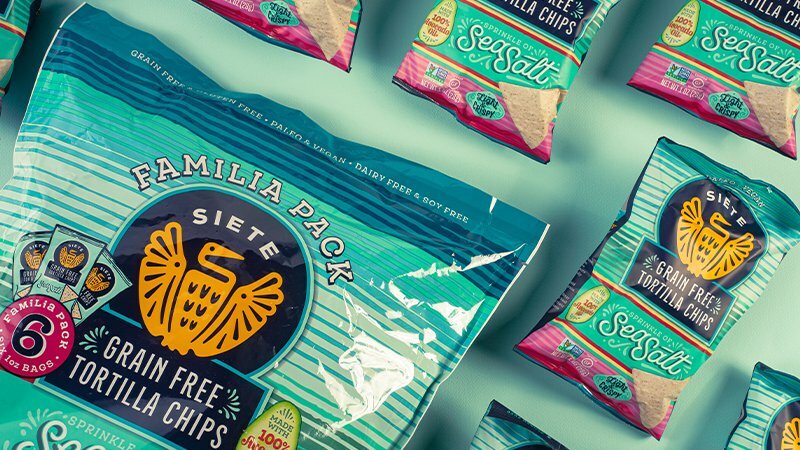 Siete Familia Pack of Grain Free Tortilla Chips with Sea Salt single-serve bags on mint green