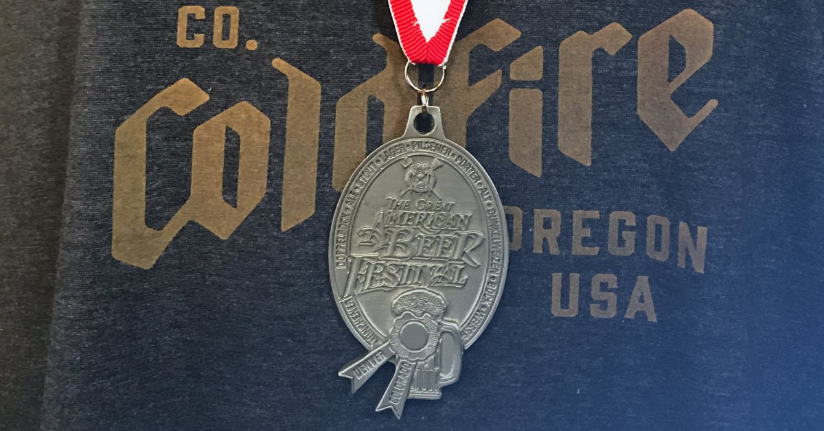 Great American Beer Festival medal resting on a Coldfire Brewing Oregon USA t-shirt