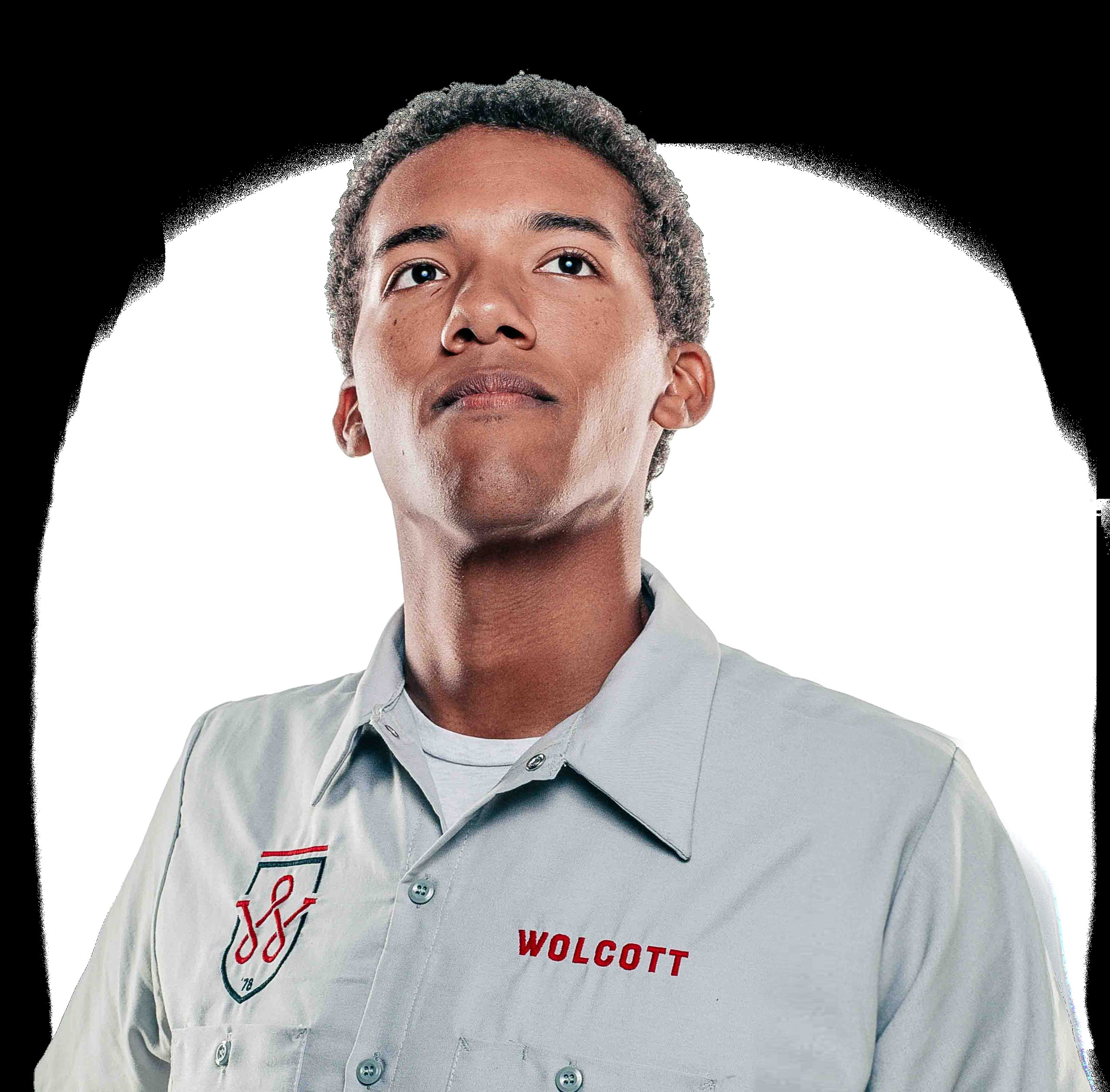 Young man in a gray Wolcott work shirt looking upward against a white background