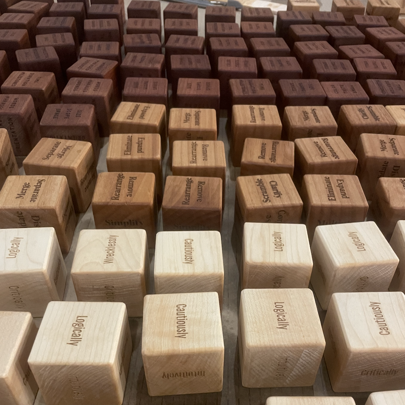 Rows of wooden cubes engraved with words like Simplify, Logically, and Rearrange