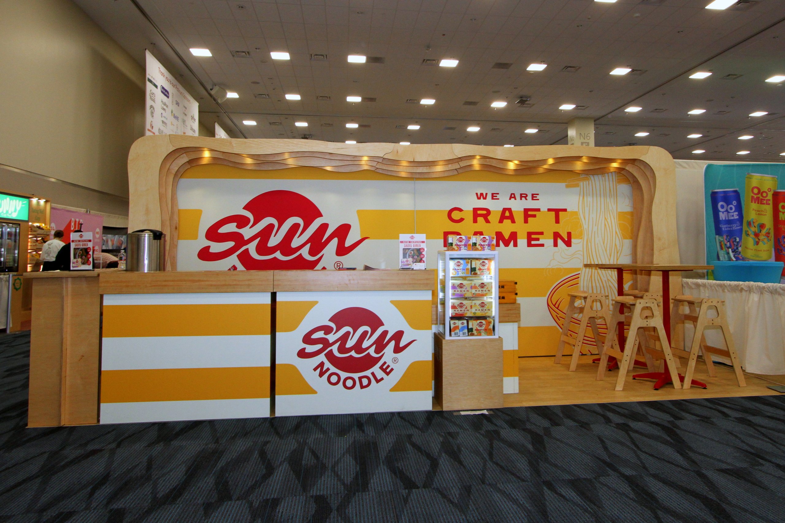 Sun Noodle trade show booth with curved wood frame and "We Are Craft Ramen"