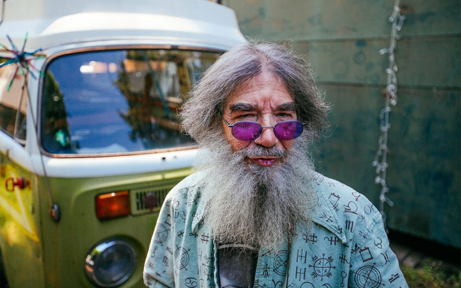 Portrait of a long-bearded man in sunglasses beside a vintage VW van, by Trask Bedortha