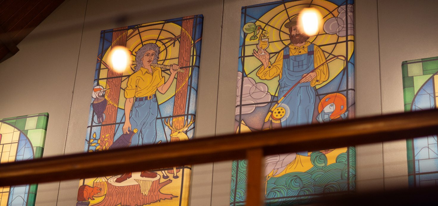 Stained-glass windows depicting figures in denim overalls inside the converted PublicHouse church
