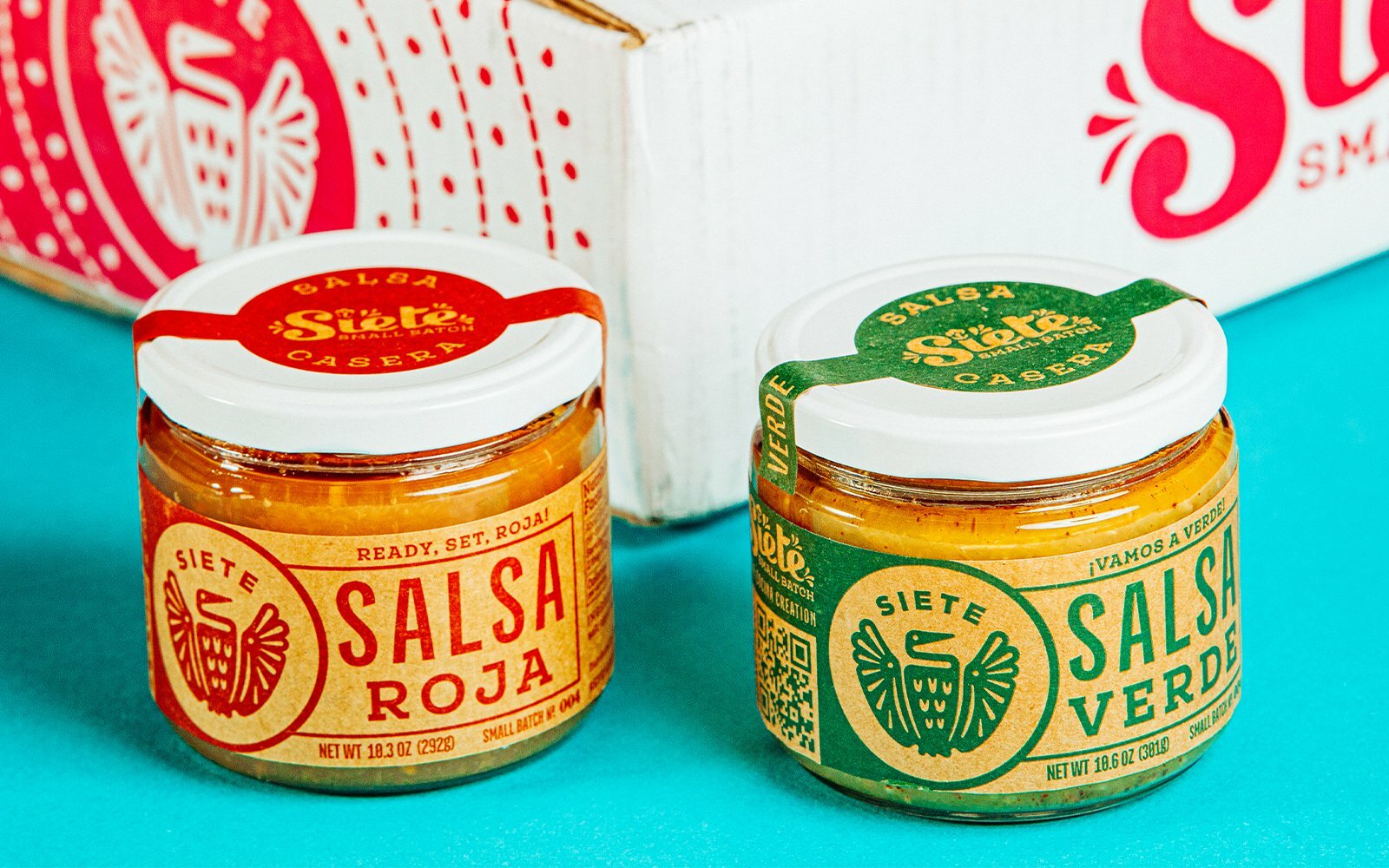 Siete Salsa Roja and Salsa Verde jars in front of a patterned box on a teal background