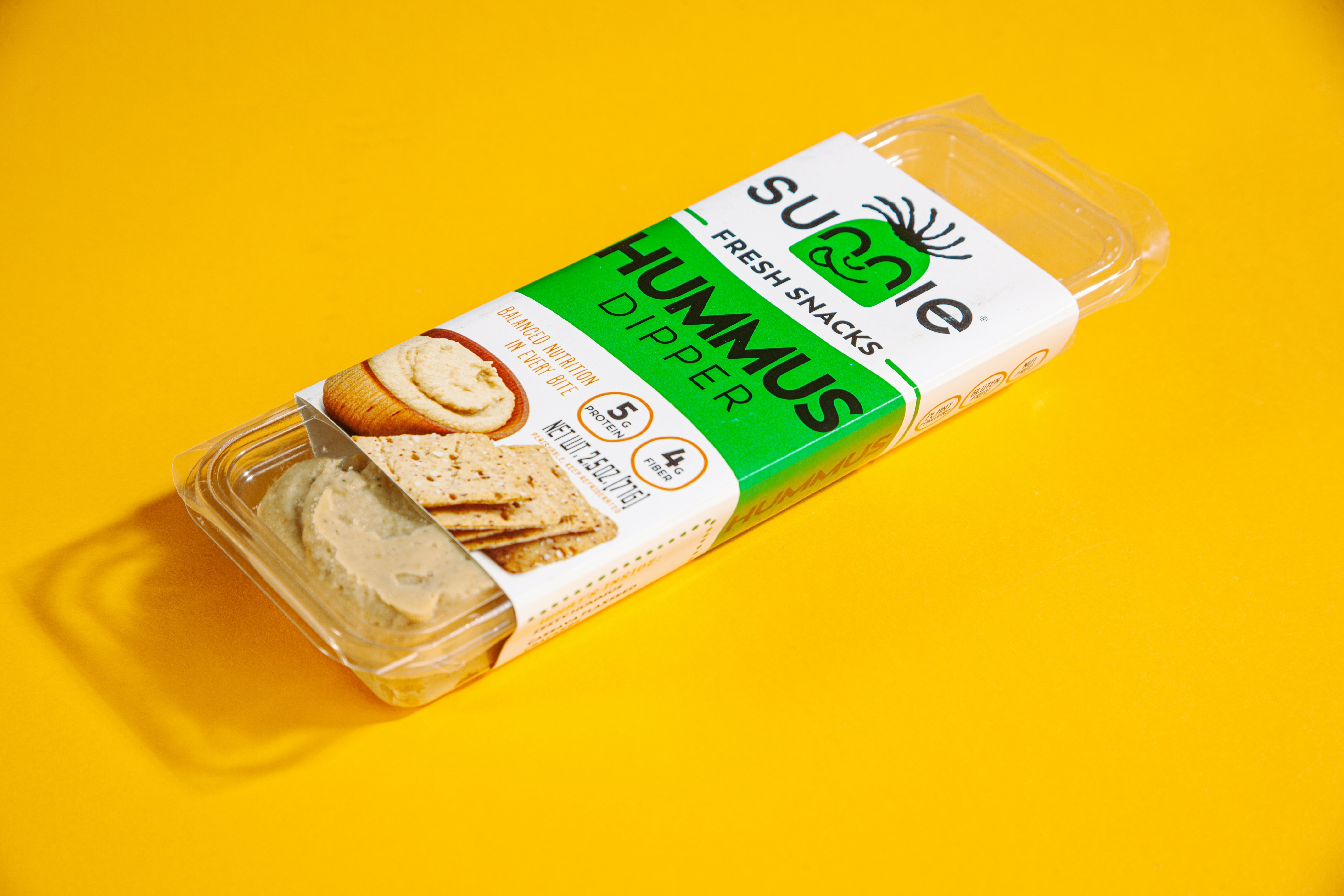 Sunnie Fresh Snacks Hummus Dipper snack pack with crackers and dip on a yellow background